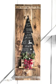 a christmas tree made out of wooden pallets on a door with a red bow