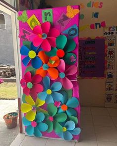 an art project made out of paper flowers and scissors on display in front of a classroom door