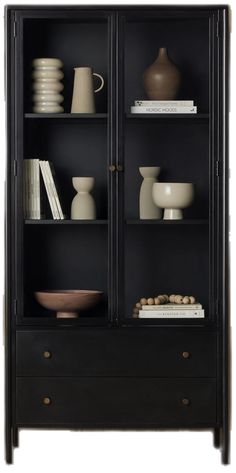 a black bookcase with glass doors and shelves filled with vases, plates and books