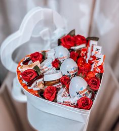 a white container filled with lots of candy and roses