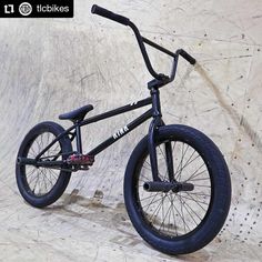 a black bmx bike sitting on top of a skateboard ramp