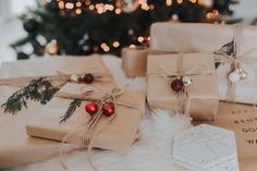 presents wrapped in brown paper and tied with twine on a table next to a christmas tree