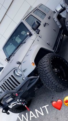 a gray jeep parked in front of a building with emoticions on the ground