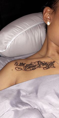 a woman laying in bed with a tattoo on her chest that says merry christmas strength