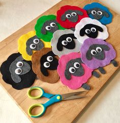 a wooden cutting board topped with cut out sheep