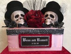 two skulls wearing hats and holding a rose in front of a sign that says bernn and russell