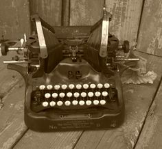 an old fashioned typewriter sitting on top of a wooden floor