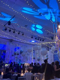 a room filled with lots of tables covered in white and blue lights