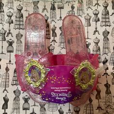 the disney princess slippers are pink with gold sequins and glitter on them