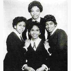 an old black and white photo of four young women posing for the camera with their arms around each other