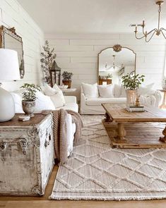 a living room filled with white furniture and lots of pillows on top of a rug