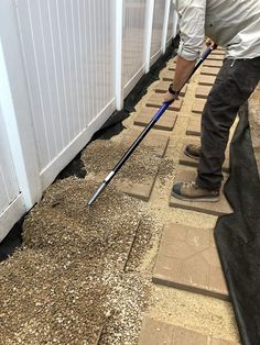 a man is cleaning the sidewalk with a mop