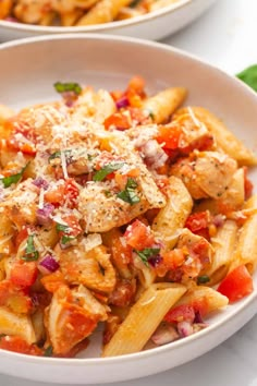 two white bowls filled with pasta and meat