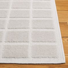 a white rug with squares on the floor