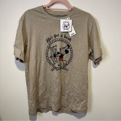 a t - shirt hanging on a hanger with a mickey mouse logo in it