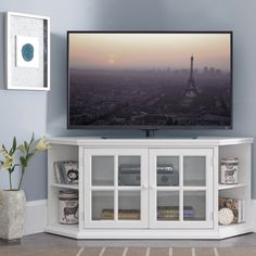 a flat screen tv mounted to the side of a white entertainment center in a living room