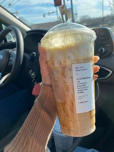 a person holding up a starbucks cup in their hand with the coffee label on it