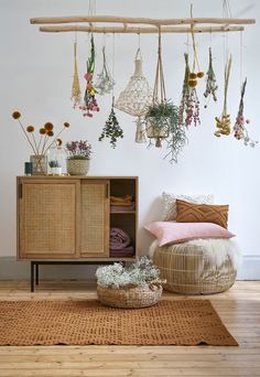 a wicker cabinet with plants hanging from it's sides in front of a white wall