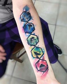 a person with a tattoo on their arm that has different shapes and colors in it