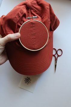 a red hat with a pair of scissors next to it