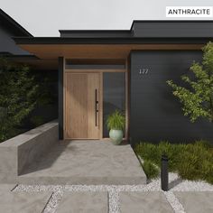 the front door of a modern house with plants and rocks on the ground in front of it