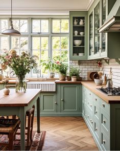 a kitchen filled with lots of green cupboards and counter top next to a stove top oven