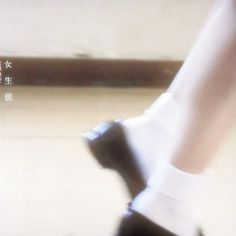 the legs and feet of a woman in white socks are seen from above, as she walks