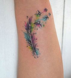 a woman's arm with a feather tattoo on it