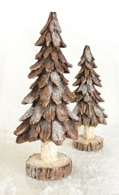 two small pine trees sitting on top of snow covered ground