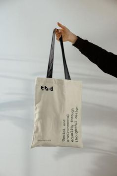 a person holding a white bag with black writing on it