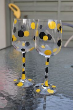 two wine glasses with yellow and black dots on them