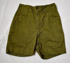 A pair of vintage 1960s or 70s khaki green cotton twill boy's or girl's military style Boy Scouts Uniform shorts.The shorts have a contoured waist with belt keepers and a fly zipper and button closure.  There are front diagonal pockets and two welt pockets at the back, one is button-through.  The shorts have been taken out at the back and the stitch marks are visible (please see the last photo).  There is a pale scuff mark on the right front leg near the hem.  No rips or holes.  25 inch waist33 inch hips, 4 1/2 inch inseam, 16 inches from the waist to the hem. 10 oz. Please also follow me on Instagram at ChrisMartinDesigns Scouts Uniform, Boy Scout Uniform, Scout Uniform, Style Boy, Military Style, Boy Scouts, Clothing Sets, Khaki Green, Military Fashion