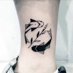 a black and white fish tattoo on the ankle, with an arrow coming out of it