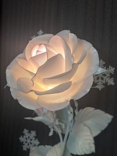 a white rose with snowflakes on it's back and its petals glowing