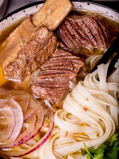 a bowl filled with meat, onions and carrots