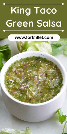 a white bowl filled with green salsa next to lettuce