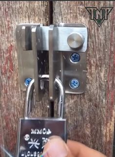 a person is holding a padlock on a wooden door