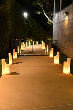 lighted candles are lined up on the sidewalk