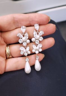 a person is holding three pairs of earrings in their hand