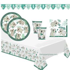 a table cloth with koalas and eucalyptus leaves on it, along with place settings