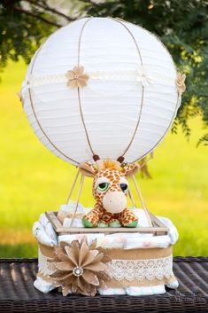 a giraffe sitting on top of a wooden table next to a white balloon