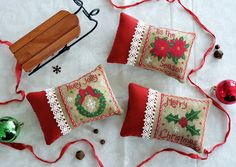 three christmas pillows and ornaments on a table