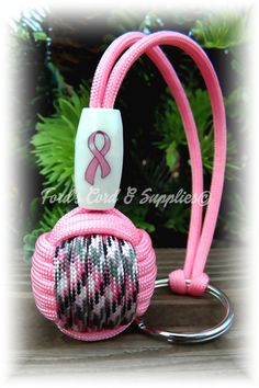 a pink lanyard with a breast ribbon on it and a keychain attached to it