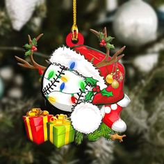 a baseball ornament hanging from a christmas tree with presents under it and decorations