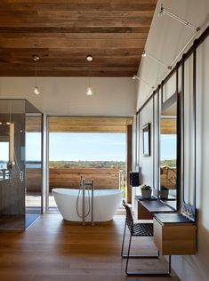 a bathroom with a large tub and wooden floors