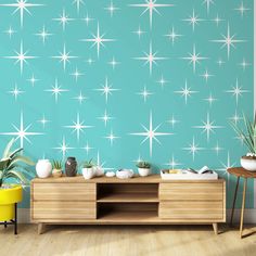 a living room with blue walls and white stars on the wall, as well as a wooden entertainment center