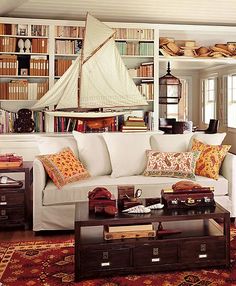 a living room filled with furniture and bookshelves covered in lots of bookcases