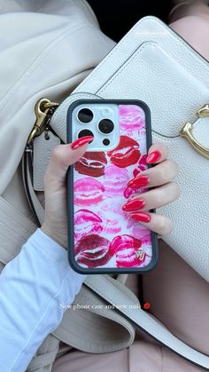 a woman holding a cell phone case with lipstick prints on it and a handbag in the background