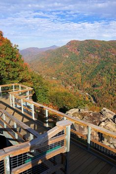 stairs lead down to the top of a mountain with autumn foliage in the valley below