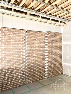 an unfinished room with exposed brick walls and beams on the ceiling is being worked on